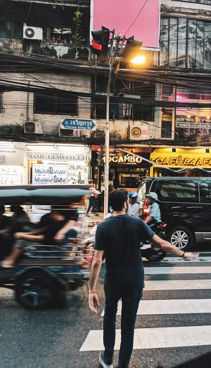 A guy walking in Bangkok with his arms out
